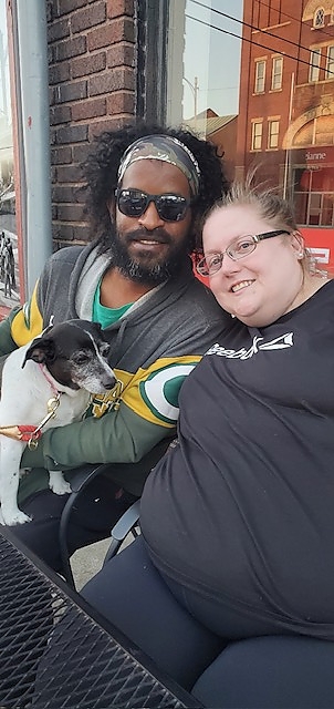  Two individuals with a dog involved in community support