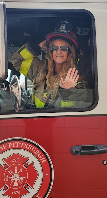  A person waving from a fire truck during a foundation event