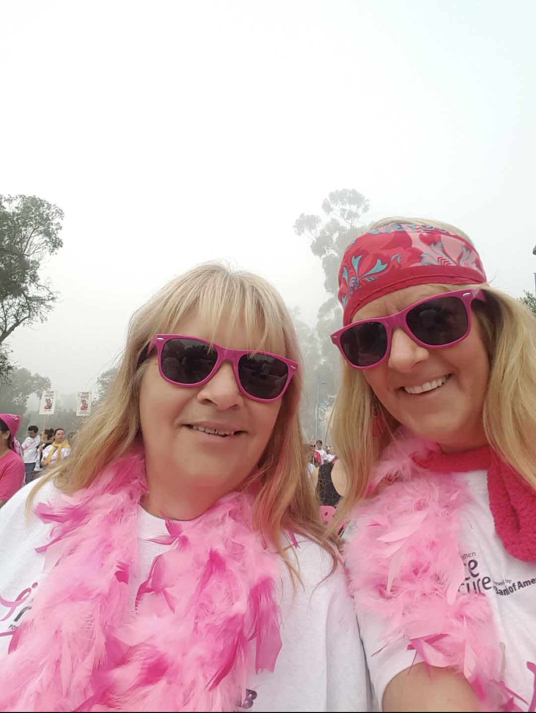 Two women in pink sunglasses and boas at a Just Believe Foundation event