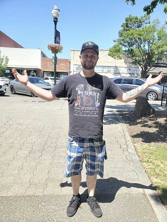 A person standing on a sidewalk with arms outstretched at a foundation event