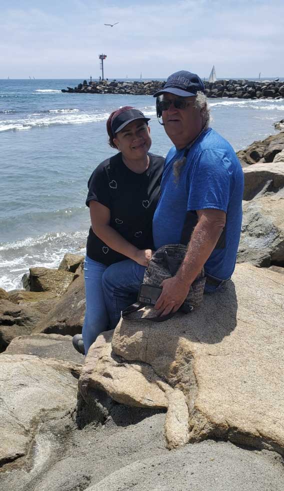 Two people sitting on rocks by the ocean in San Diego